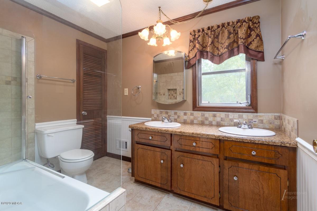 6663 Goodall Mill Road Macon, GA 31216 - Photo 16 of 31 a spacious bathroom with a granite countertop sink a toilet and a mirror