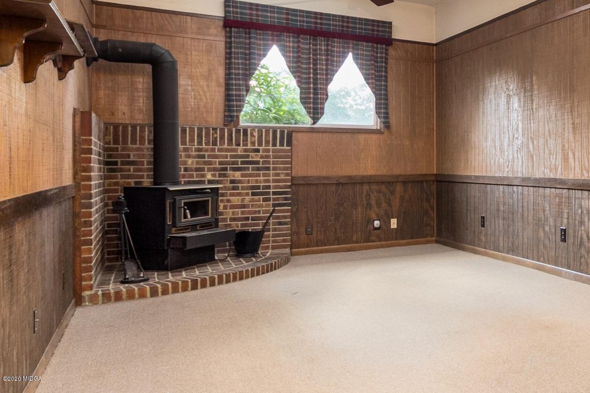 6663 Goodall Mill Road Macon, GA 31216 - Photo 19 of 31 a view of an empty room with a fireplace and windows