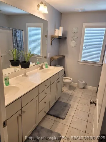 a bathroom with a sink a toilet and mirror