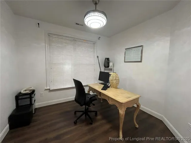a view of a workspace with furniture and wooden floor