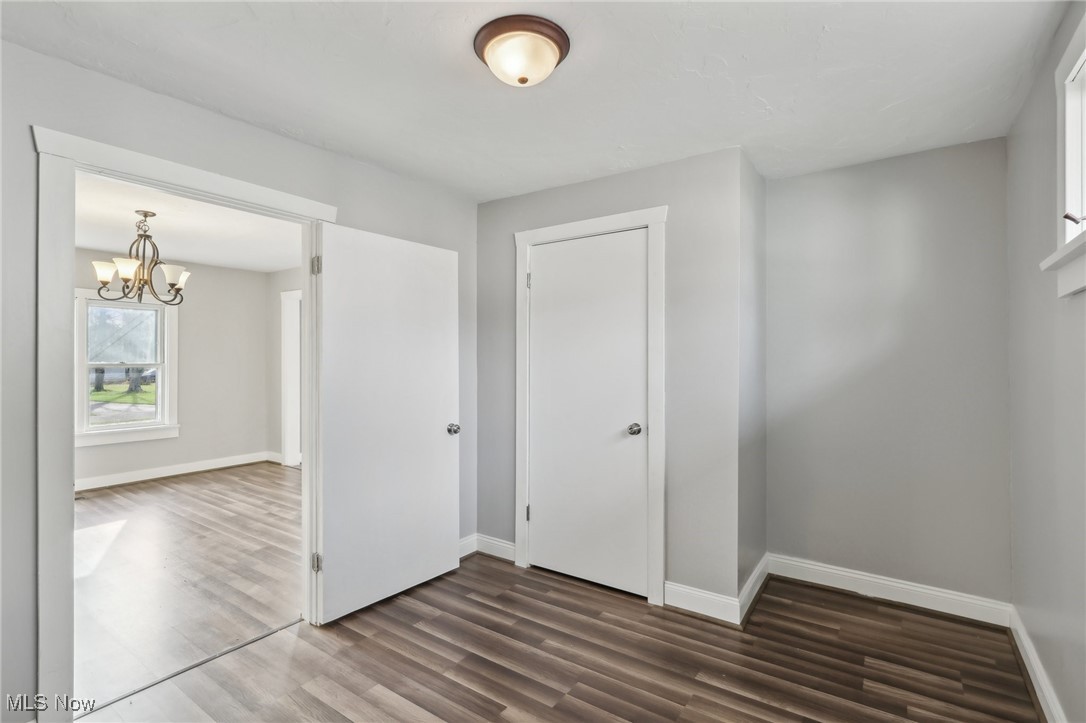 311 Warren Road Newton Falls, OH 44444 - Photo 14 of 30 Spare room featuring dark hardwood / wood-style floors and a notable chandelier