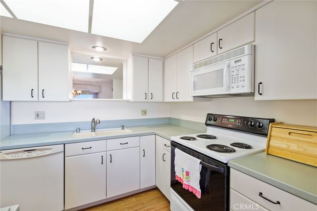 a kitchen with cabinets appliances a sink and a stove