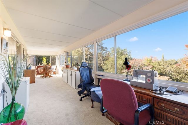 a dining room with furniture and a floor to ceiling window