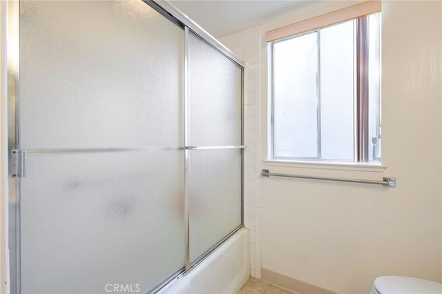a view of a hallway with wooden floor and windows