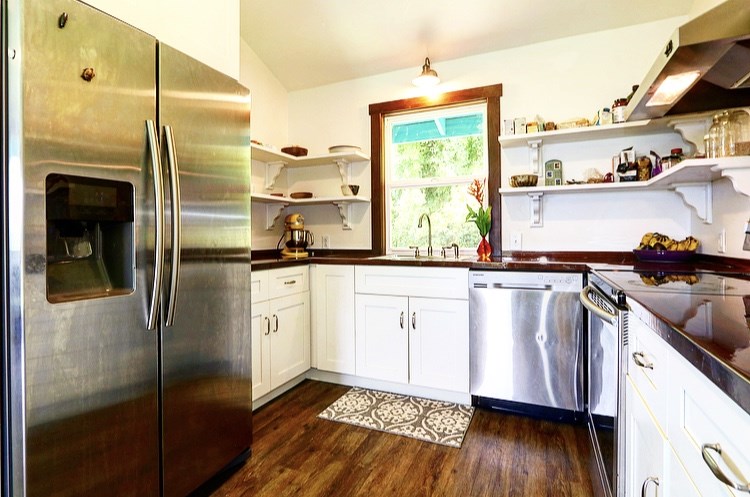 1001 Kauhikoa Road Haiku, HI 96708 - Photo 21 of 30 a kitchen with stainless steel appliances a refrigerator a sink and wooden floors