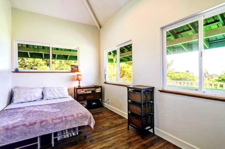 1001 Kauhikoa Road Haiku, HI 96708 - Photo 24 of 30 a bedroom with a bed and wooden floor