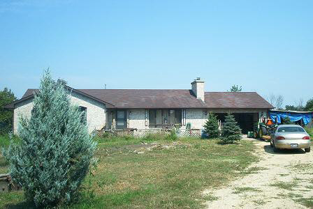 3998 East Whitaker Road Byron, IL 61010 - Photo 1 of 6 a front view of a house with garden