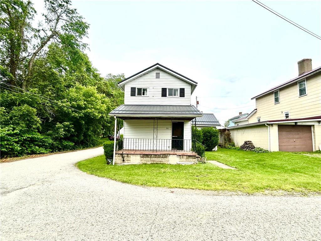 301 4th Street Allison, PA 15413 - Photo 25 of 29 a view of a white house with a small yard and large trees