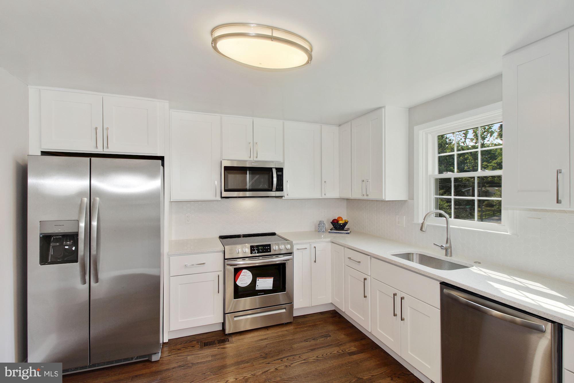 7003 Kenleigh Road Baltimore, MD 21212 - Photo 5 of 28 a kitchen with stainless steel appliances a refrigerator sink and stove