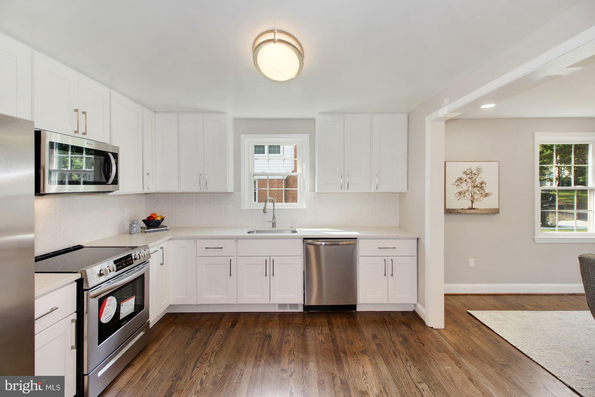 7003 Kenleigh Road Baltimore, MD 21212 - Photo 6 of 28 a kitchen with granite countertop a stove top oven sink and cabinets