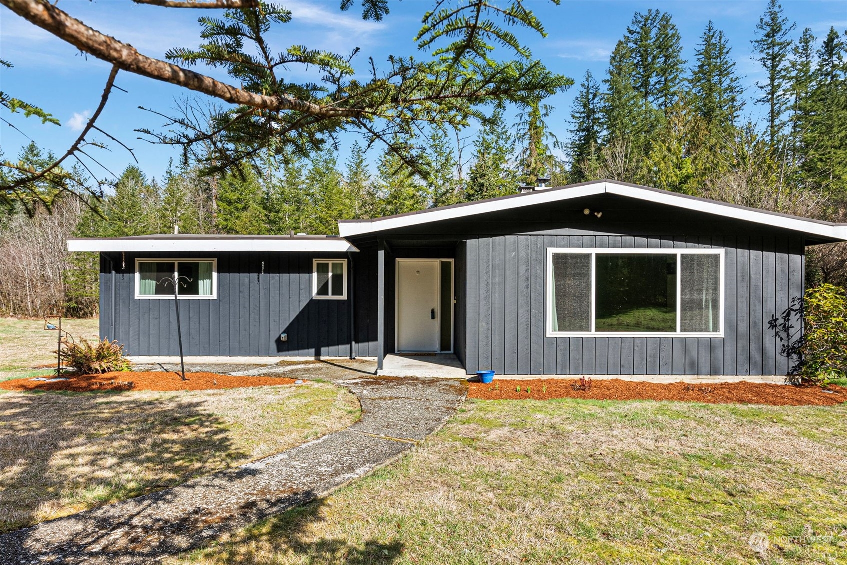 a front view of a house with a yard covered with snow in front of house