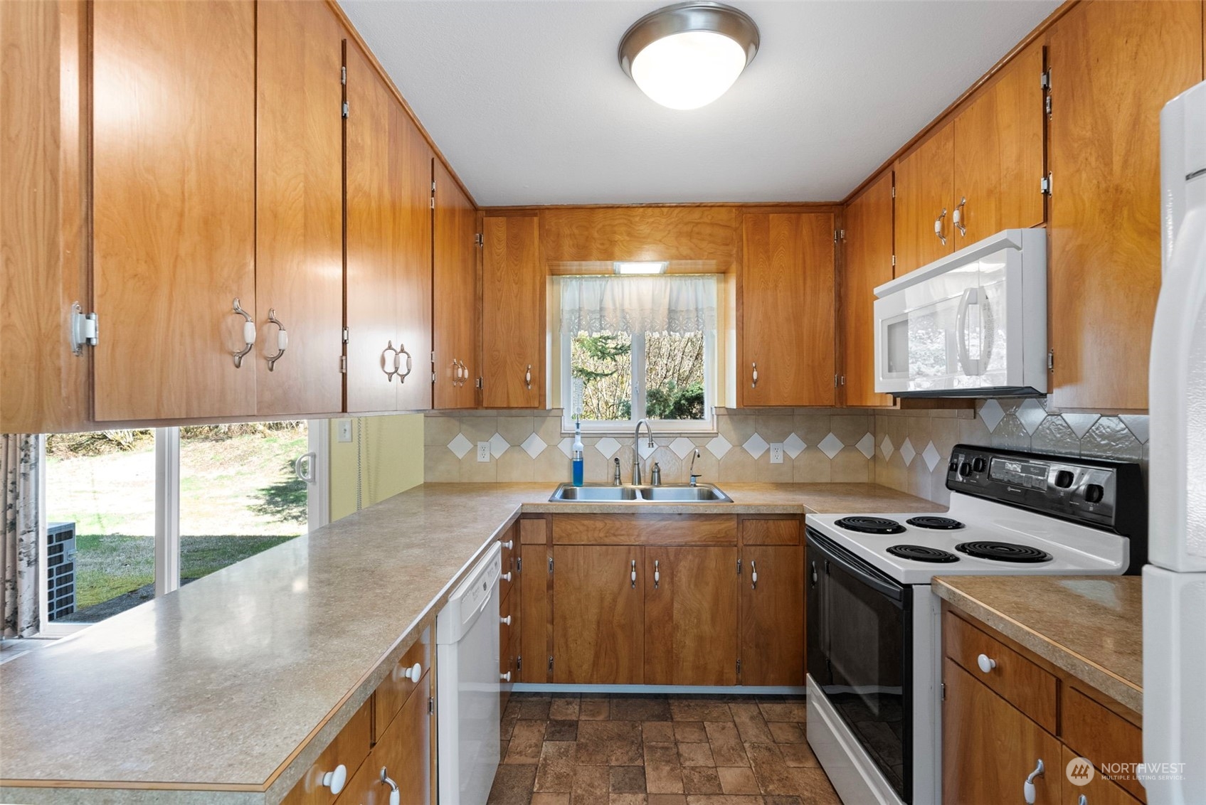 44223 Southeast Ernies Grove Road Snoqualmie, WA 98065 - Photo 10 of 21 a kitchen with stainless steel appliances granite countertop a sink a stove and a wooden cabinets