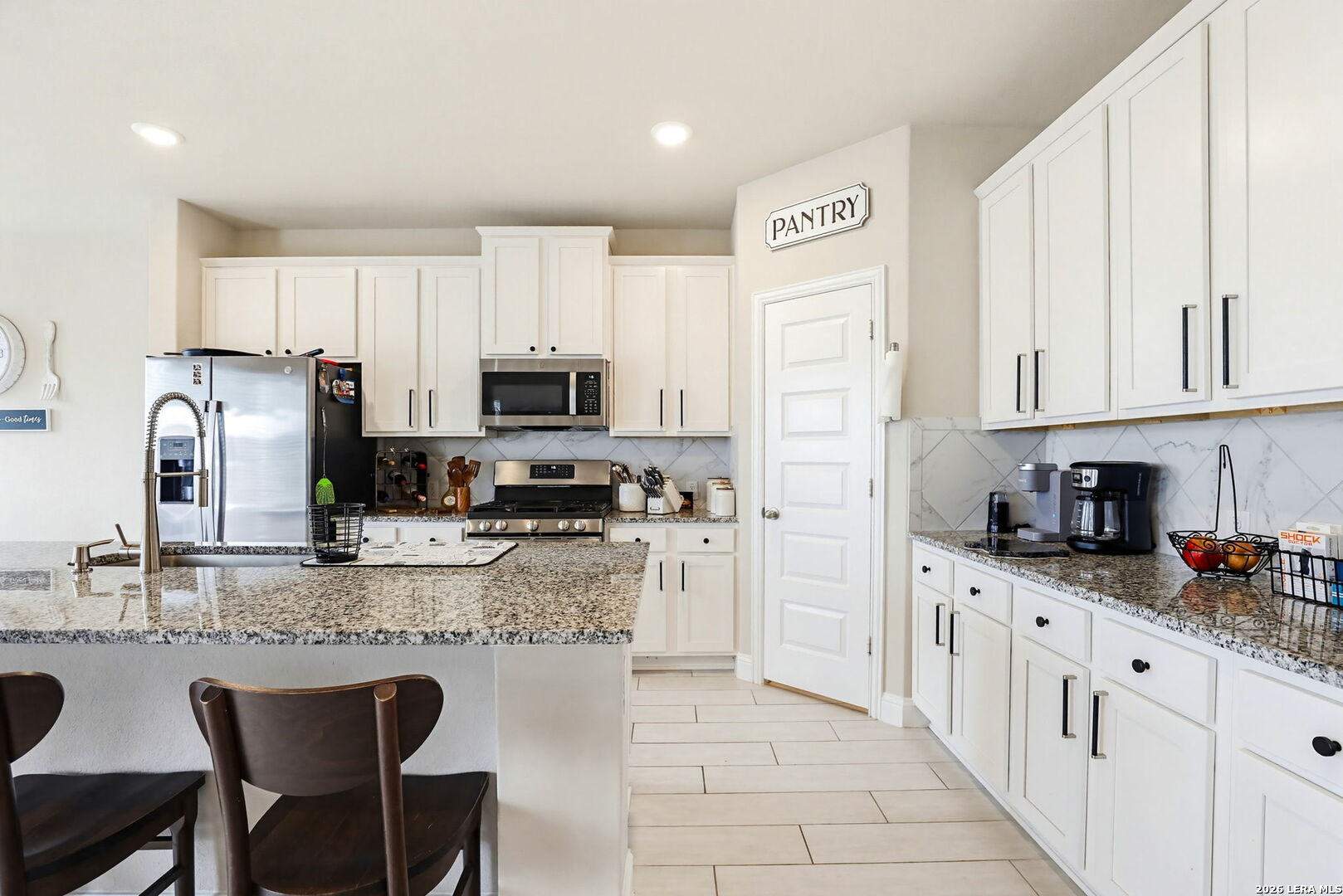 4174 Garden Path Marion, TX 78124 - Photo 4 of 21 a kitchen with stainless steel appliances granite countertop a stove top oven a refrigerator a sink and dishwasher with white cabinets