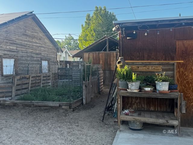 625 East Inyo Street Lone Pine, CA 93545 - Photo 12 of 16 a view of a house with a small yard and wooden fence