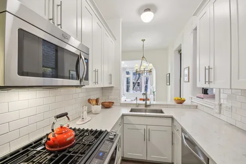 a kitchen with stainless steel appliances a sink a stove and cabinets