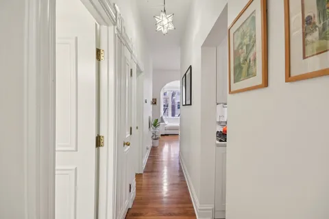 a view of a hallway with wooden floor and staircase