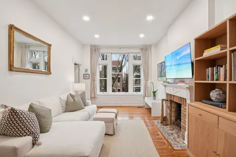 a living room with furniture a fireplace and a large window