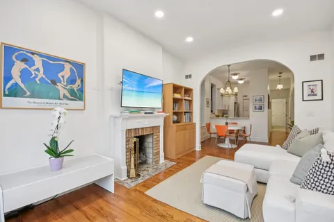 a living room with furniture fireplace and wooden floor