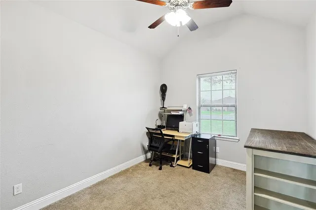 a view of a workspace with furniture and a window