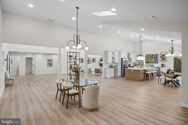 a kitchen with a dining table chairs sink and stove