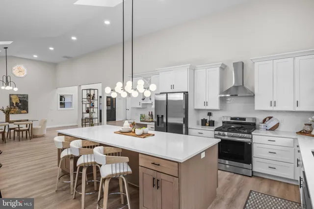 a kitchen with a dining table chairs and chandelier