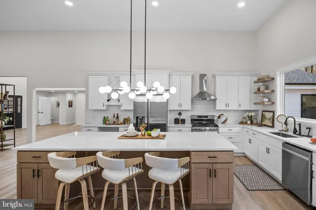 a view of a dining room and livingroom with furniture wooden floor a chandelier