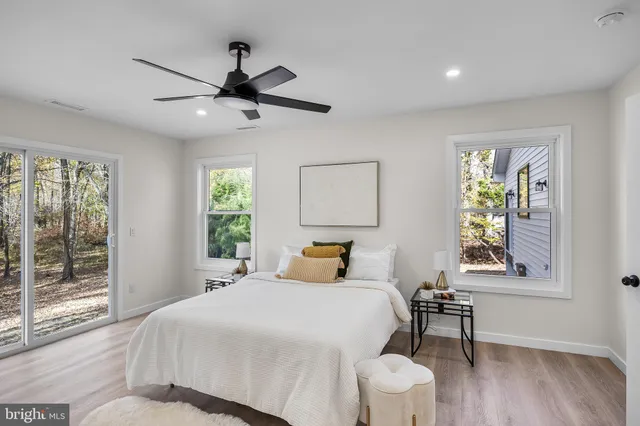 a bedroom with a bed a window and a painting on the wall