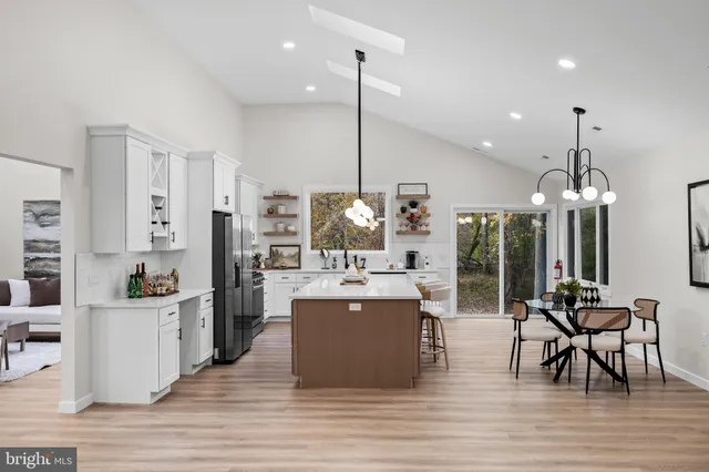 a view of a dining hall with floor to ceiling windows and kitchen view