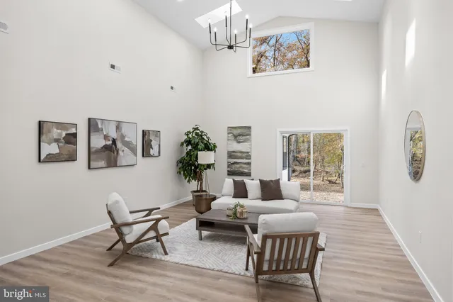 a living room with furniture wooden floor and a chandelier
