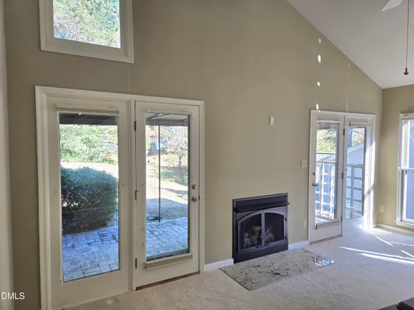 a view of an empty room with window and fire place