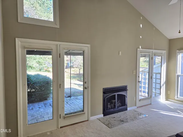 a view of an empty room with window and fire place