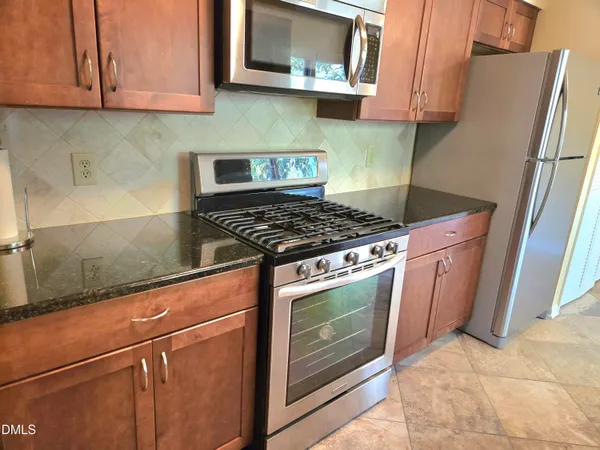 a kitchen with granite countertop cabinets stainless steel appliances and a sink