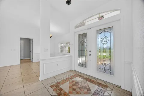 a view of a livingroom with a chandelier fan and windows