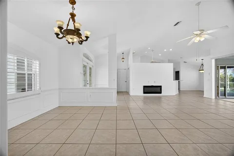 an empty room with windows and ceiling fan