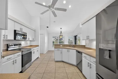 a kitchen with stainless steel appliances granite countertop a sink a stove top oven a counter space and cabinets