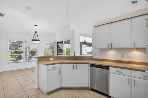 a kitchen with white cabinets and black appliances