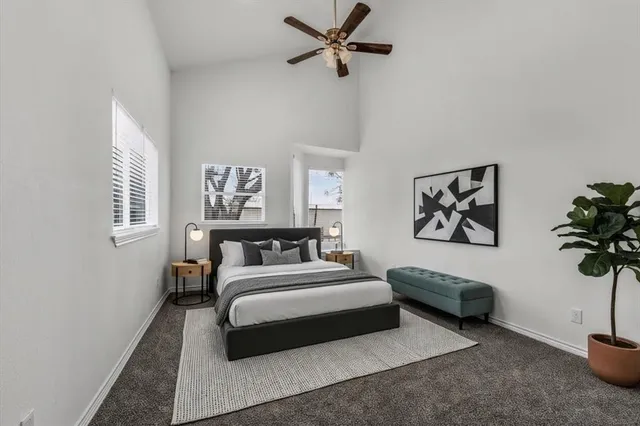 a spacious bedroom with a bed a couch and a potted plant