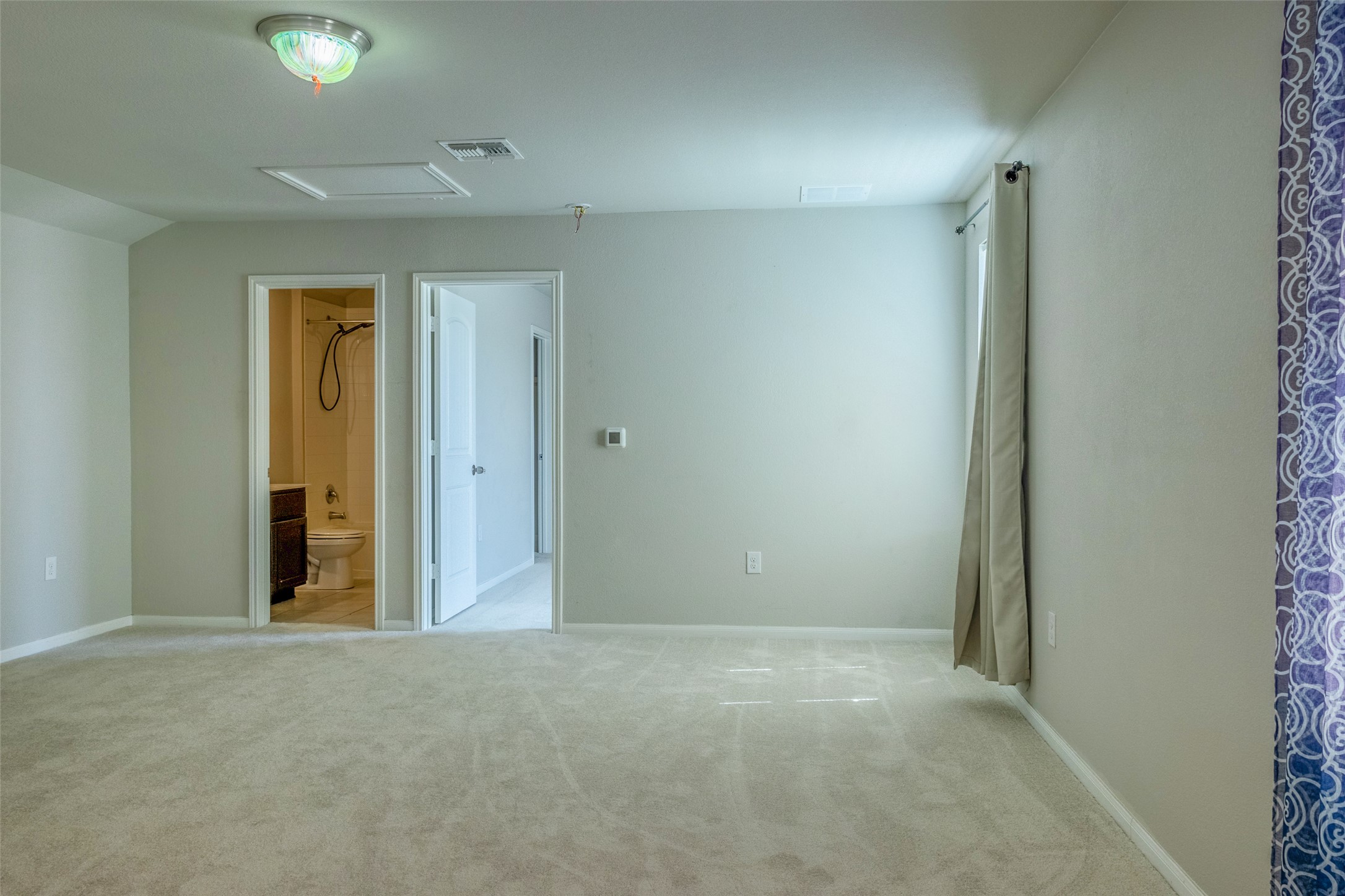 7225 Ranchito Drive Austin, TX 78744 - Photo 21 of 39 A spacious room offers comfortable carpet flooring and easy access to a full bathroom.