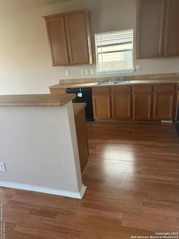 an empty room with wooden floor and cabinet