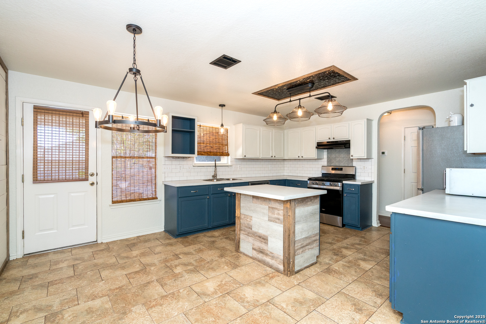 720 Fountain Gate Schertz, TX 78108 - Photo 11 of 34 a kitchen with kitchen island granite countertop a stove top oven a sink a counter top space and cabinets
