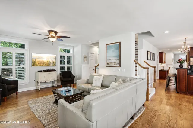 a kitchen with stainless steel appliances kitchen island granite countertop wooden cabinets a stove a dining table and chairs