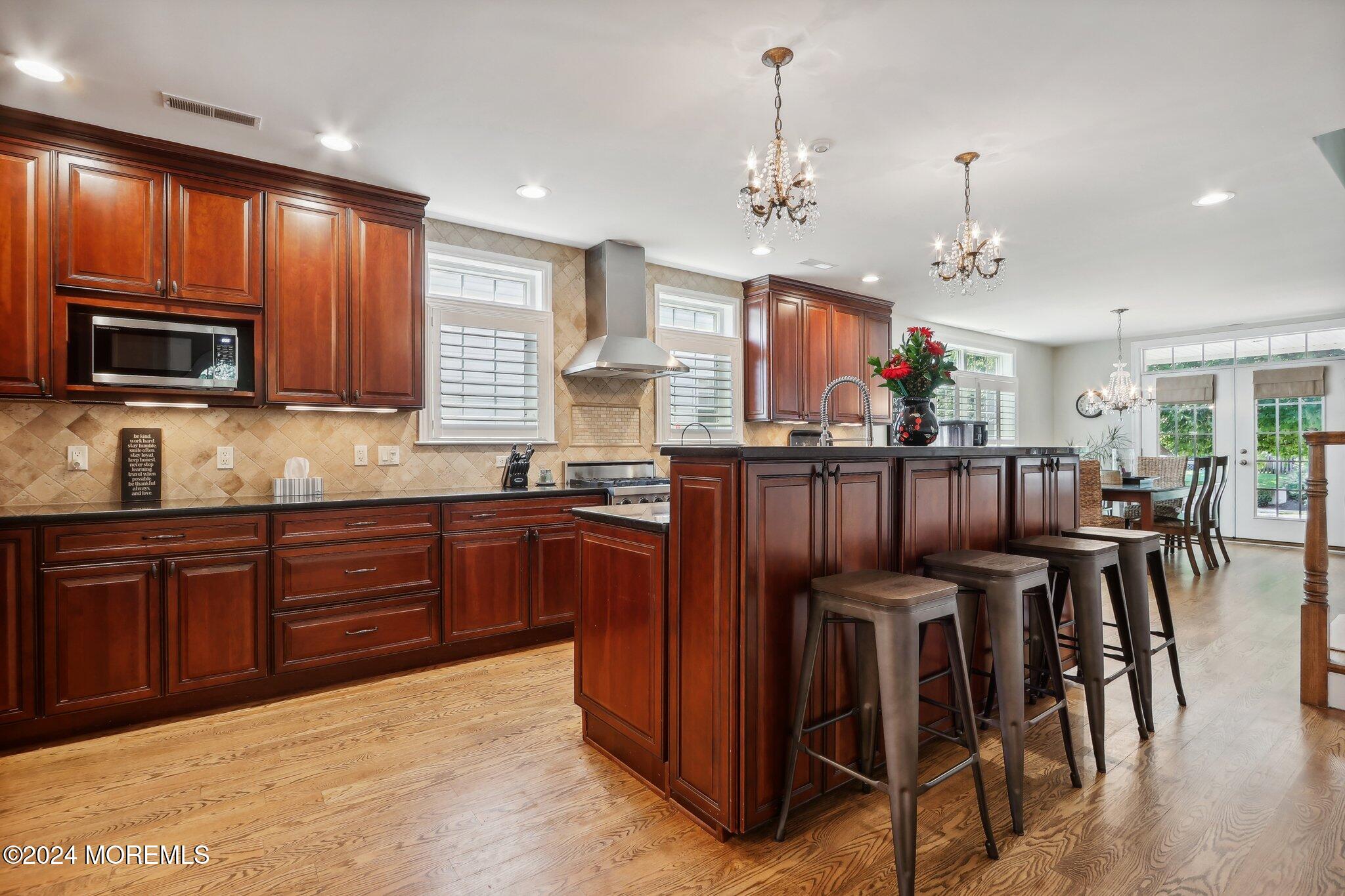 317 Worthington Avenue Spring Lake, NJ 07762 - Photo 26 of 85 a kitchen with stainless steel appliances kitchen island granite countertop wooden cabinets a stove a dining table and chairs