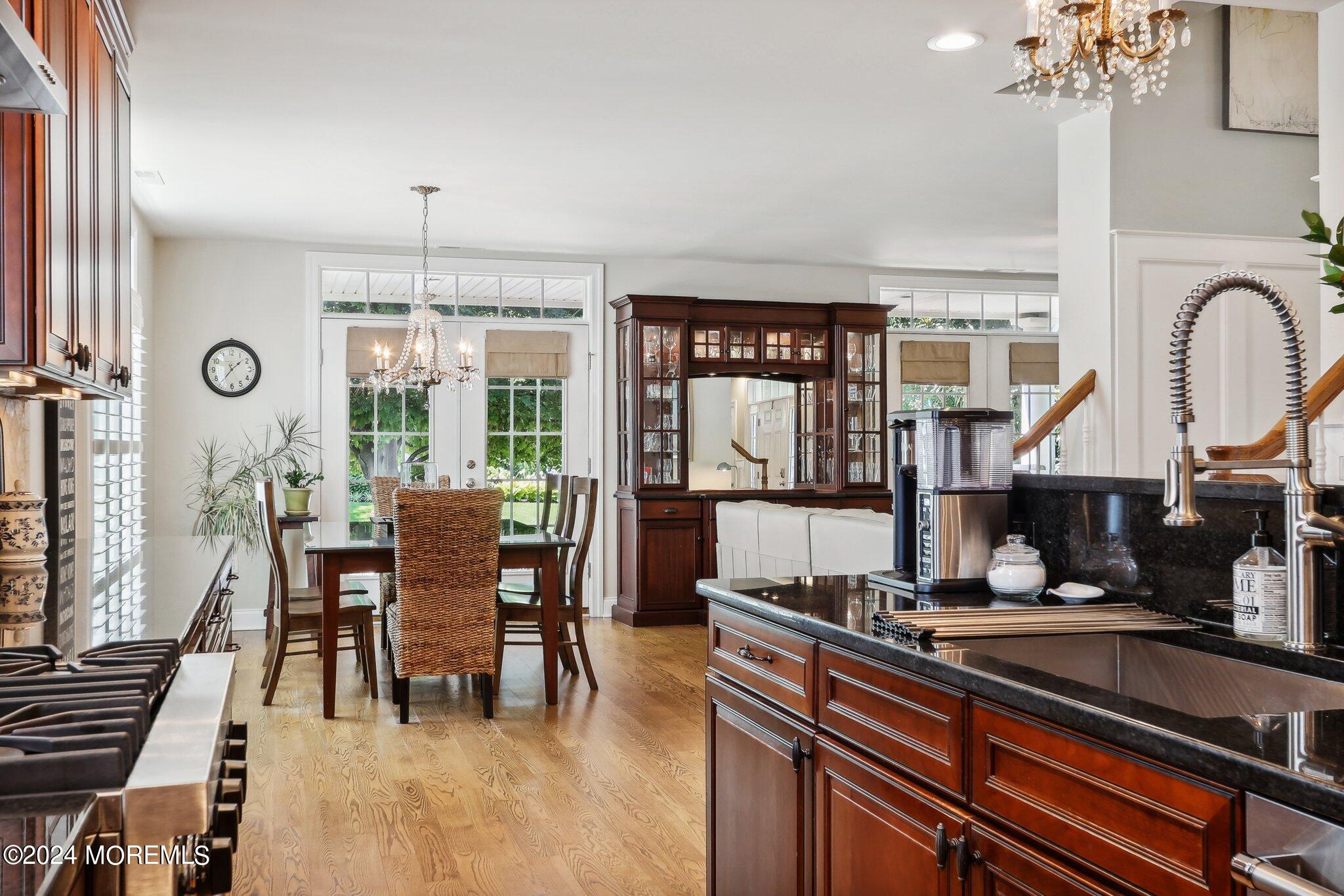 317 Worthington Avenue Spring Lake, NJ 07762 - Photo 28 of 85 a kitchen with stainless steel appliances granite countertop a stove top oven a sink a dining table and chairs with wooden floor