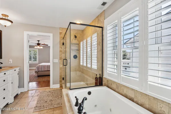 a bedroom with a bed a chair and potted plant on dresser