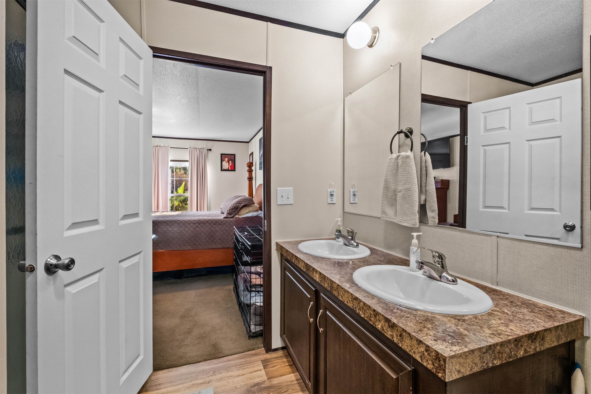 57443 667th Colcord, OK 74338 - Photo 23 of 51 Dual vanity with integrated sinks, wood-finish flooring, and wall-mounted lighting