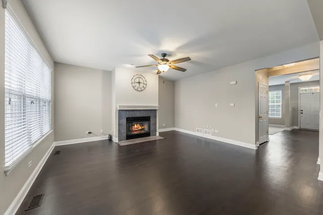 an empty room with windows and a fireplace