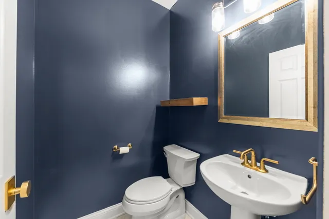 a bathroom with a toilet a sink and mirror