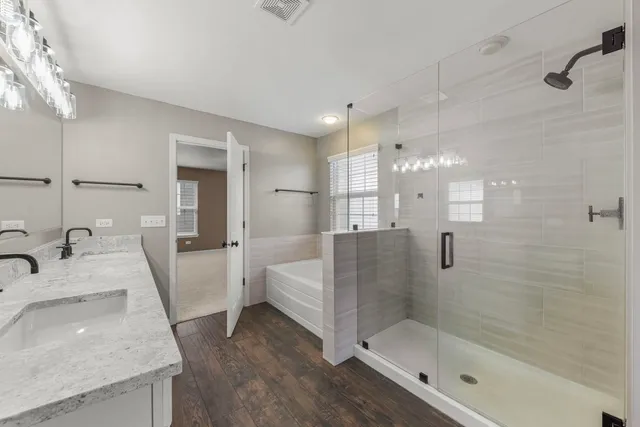 a bathroom with a granite countertop sink a toilet and shower