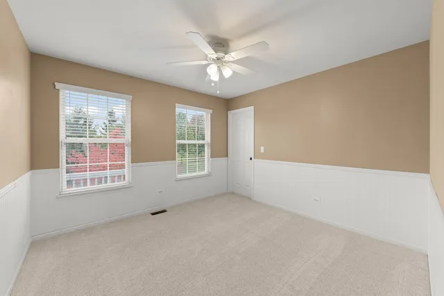 an empty room with a window and a ceiling fan