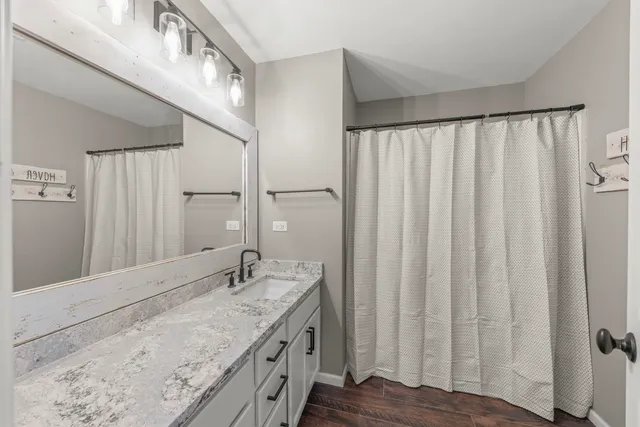 a bathroom with a granite countertop sink and a mirror